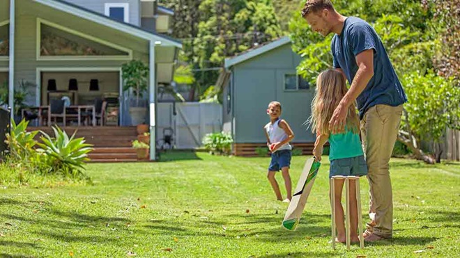 family playing cricket in backyard